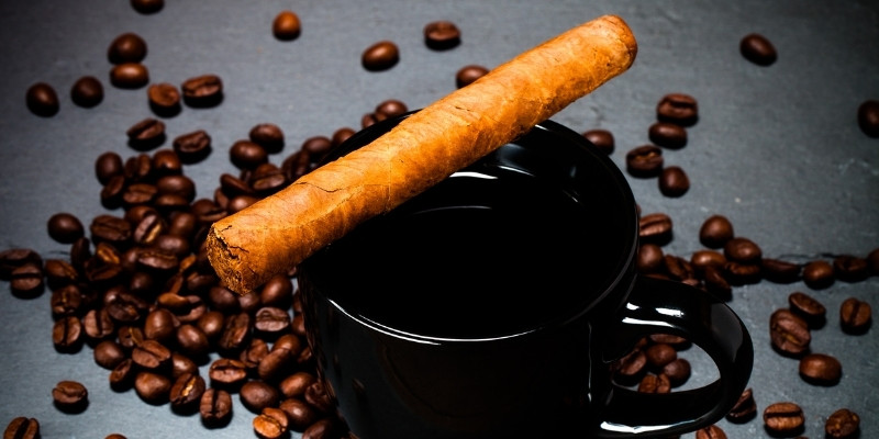 Coffee and cigar with coffee beans around