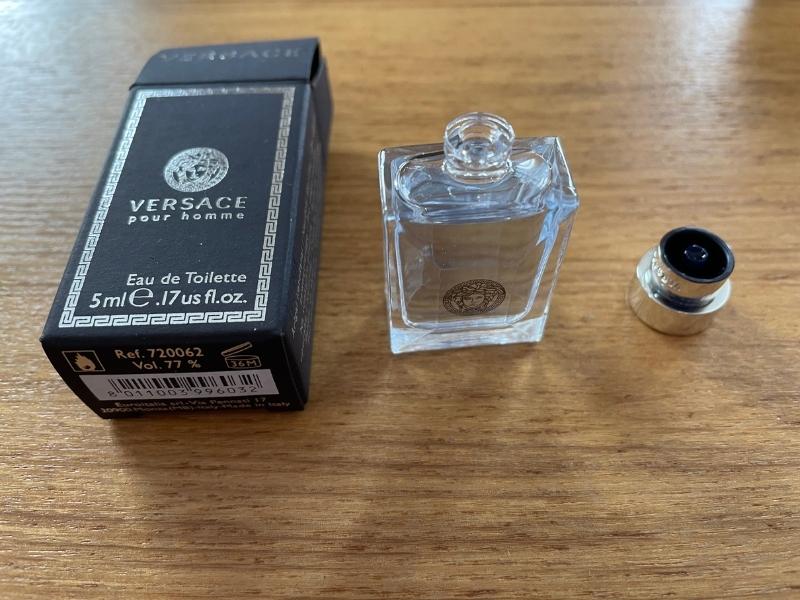 versace pour homme open bottle with cap removed next to open box