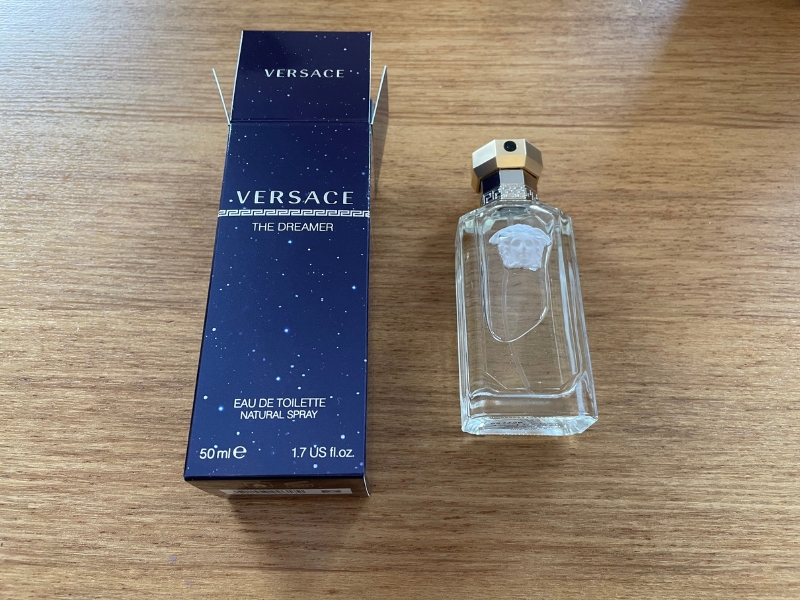 versace dreamer opened box next to bottle of cologne